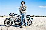 Portrait of young male motorcyclist on arid plain, Cagliari, Sardinia, Italy