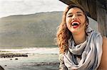 Young woman laughing on coastal pier, Cape Town, Western Cape, South Africa