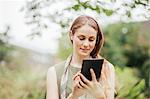 Young woman using touchscreen on digital tablet in field