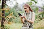 Young woman using digital tablet in field