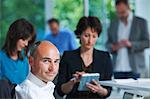 Portrait of businessman in front of colleagues in office