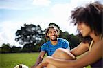 Young soccer couple taking a break in park