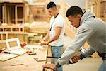 Two male college students in woodworking workshop