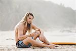 Australian surfer using smartphone, Bacocho, Puerto Escondido, Mexico