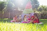 Five girls playing with teddy bears in front of teepee