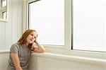 Portrait of girl gazing out of holiday apartment window