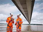 Bridge workers in meeting under suspension bridge. The Humber Bridge, UK was built in 1981 and at the time was the world's largest single-span suspension bridge