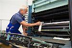 Factory worker cleaning machinery