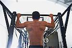 Crossfitter doing pull ups in gym