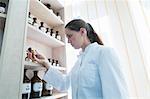 Pharmacist in pharmacy holding medicine bottle