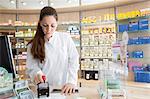 Pharmacist in pharmacy stamping prescription