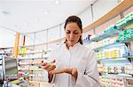 Pharmacist in pharmacy holding medicine in hand