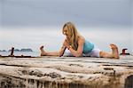 Mid adult woman with hands together practicing yoga on wooden sea pier