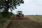 Farmer driving tractor and planting seed corn in field