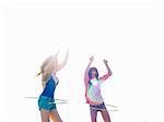 Two young women friends swinging hoola hoops on beach, Williamstown, Melbourne, Australia