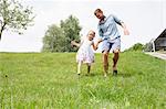 Father and daughter running downhill