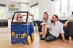 Parents watching daughter in homemade toy car