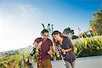 Couple opening champagne in penthouse rooftop garden, La Jolla, California, USA