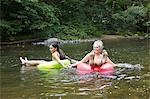 Women in river with inflatable rings