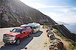 Pick-up truck with trailer attached on mountain road, Big Sur, California, USA