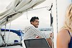 Young man on sailing boat, laughing