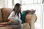 Woman stroking cat on couch