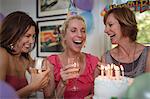 Three mature women at birthday party, laughing