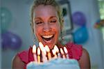 Mature woman holding birthday cake with candles