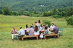 Family having meal together and socialising, outdoors