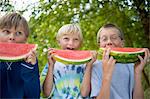 Friends eating watermelon in garden