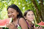 Friends eating watermelon in garden