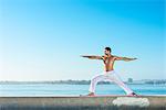 Young man practicing yoga position at Pacific beach, San Diego, California, USA