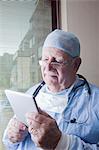 Senior surgeon reading digital tablet