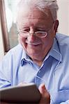 Senior man reading digital tablet