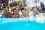 Portrait of family with two children in swimming pool