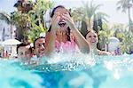 Family with two children enjoying themselves in swimming pool