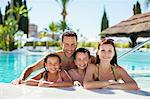 Portrait of family with two children in swimming pool