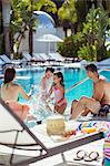 Family with two children splashing water in resort swimming pool