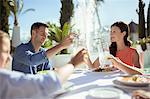 Family raising toast at table outdoors