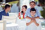 Portrait of smiling brother and sister, parents sitting at table in background