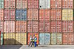 Workers walking together near stack of cargo containers