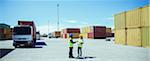 Workers talking near cargo containers