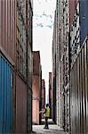 Worker standing between cargo containers