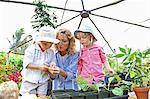 Woman with two children planting seedlings in greenhouse
