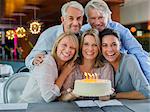 Portrait of smiling mature men and women with birthday cake