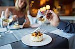 Couple eating dessert in fancy restaurant