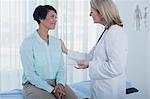 Smiling female doctor talking to patient in office