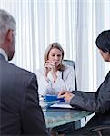 Female doctor, man and woman sitting at table in office