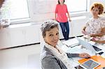 Portrait of smiling mature businesswoman at desk in office