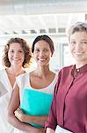 Portrait of three smiling businesswomen standing in office